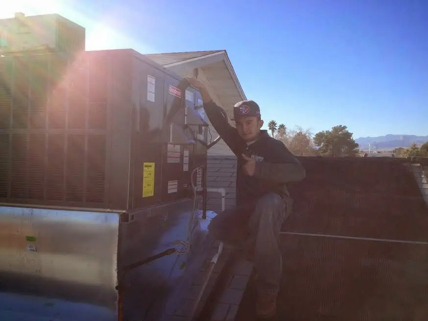 HVAC technician performing HVAC Inspection on a rooftop unit in Hampstead